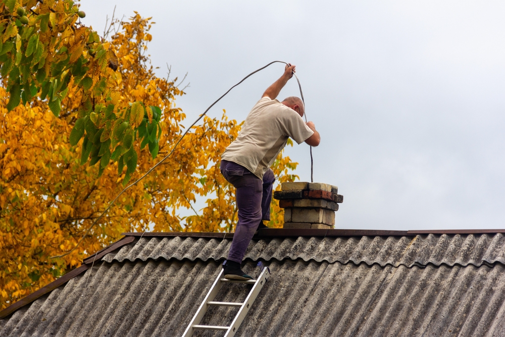 A,Male,Chimney,Sweep,Cleans,The,Chimney,From,Soot,On