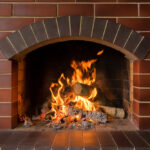 A,Brick,Fireplace,In,Which,A,Fire,Burns