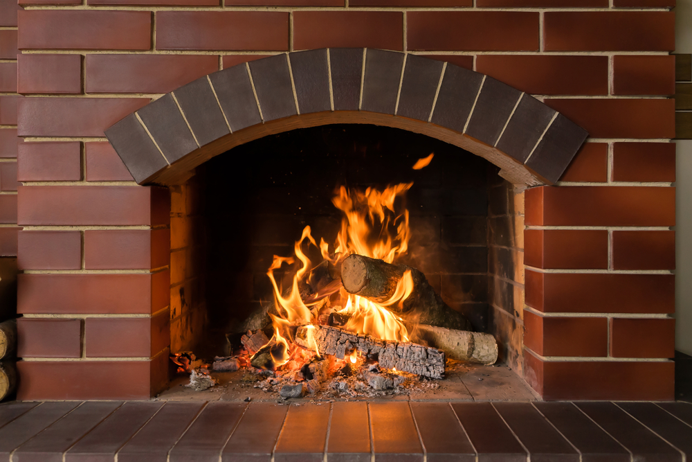 A,Brick,Fireplace,In,Which,A,Fire,Burns